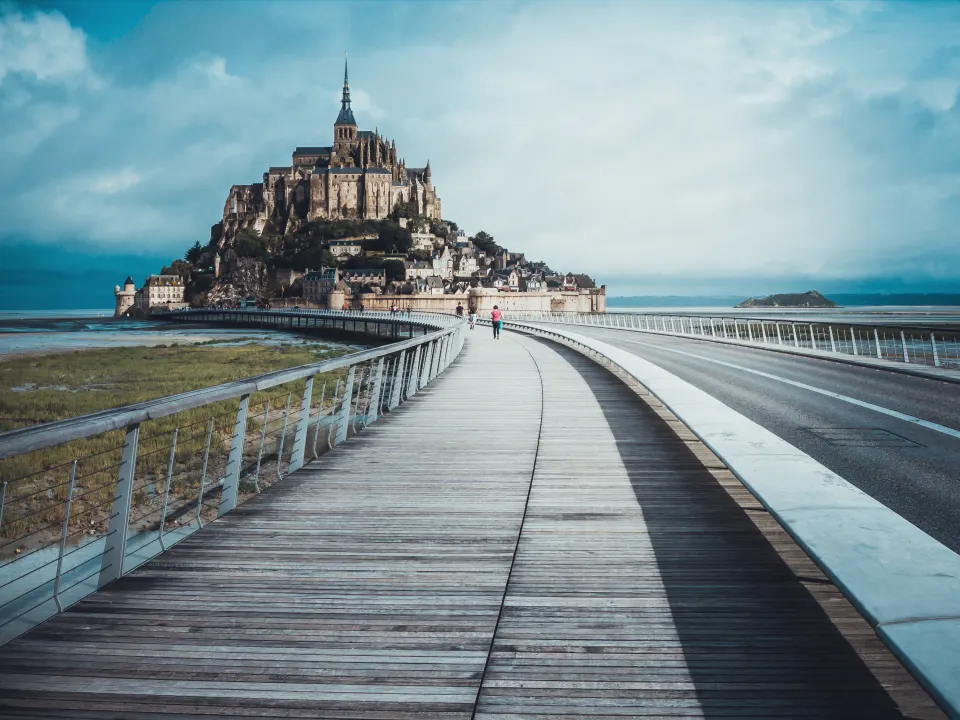 Le Mont-Saint-Michel au bout de la passerelle, sous un ciel de tempête
